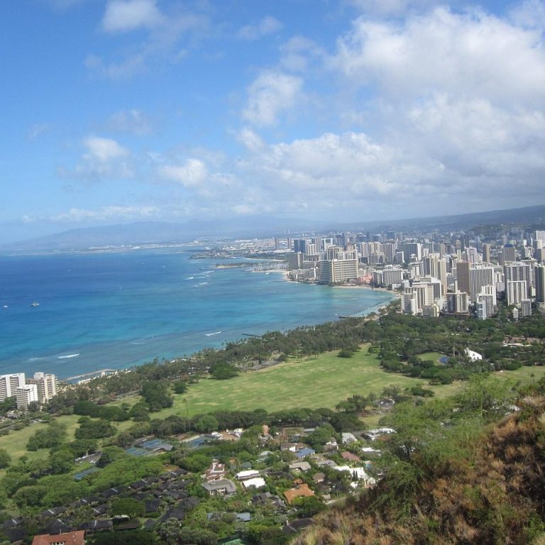 Honolulu Panoramablick auf die Küste in Honolulu mit Stadt, Meer und bewaldeten Hügeln.